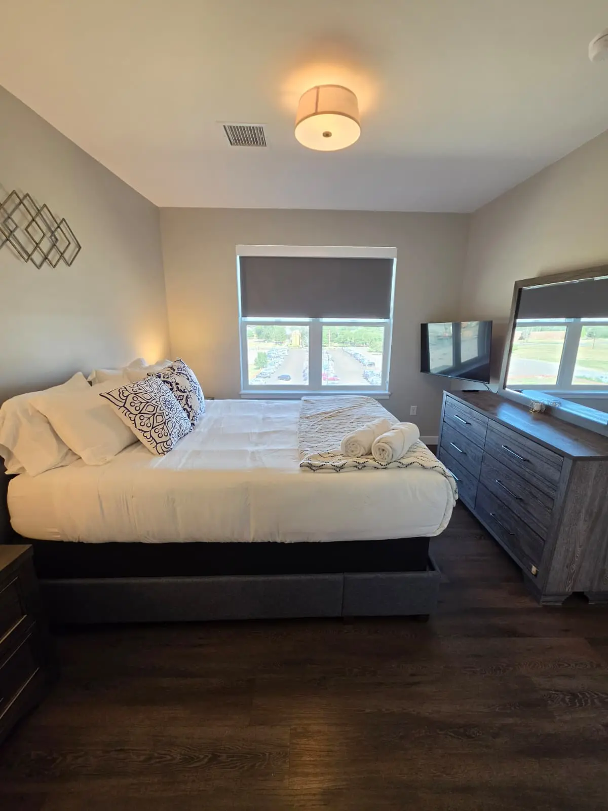 Bedroom with queen bed, dresser, and television in a furnished Aurora, Colorado rental